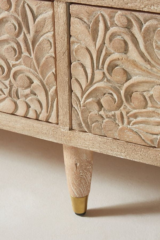 Close-up of a leg on the beige Gulliver bureau, showing its finish and the lower edge of the dresser.