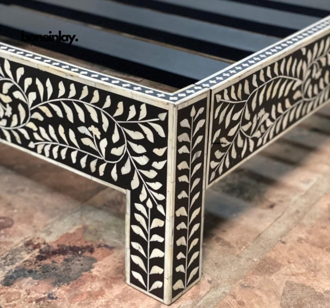 Corner detail of Black Bone Inlay Bed Frame showing hand-carved floral leaf pattern on platform base and legs with white inlay on black wood – Indian Artisan Furniture