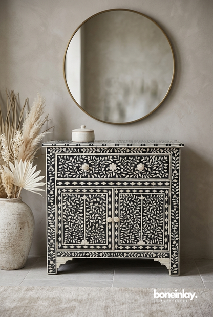 Black bone inlay storage cabinet with all-over ivory floral vine inlay, 1 drawer, 2 doors with bone knobs and diamond border, white background