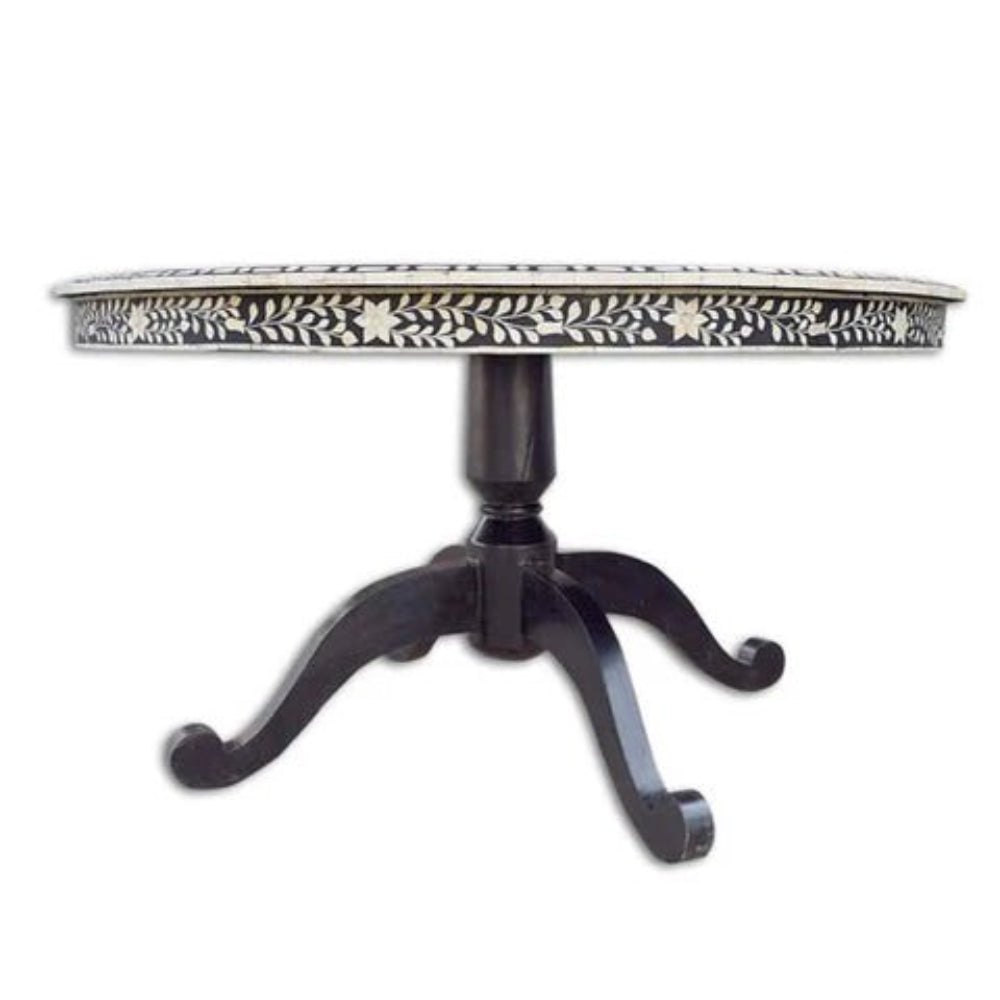 Black bone inlay round dining table with white floral vine apron detail and carved dark wood pedestal base on white background