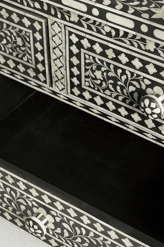 Angled close-up of open drawer on black bone inlay dresser highlighting bone knob and geometric diamond inlay pattern on drawer front