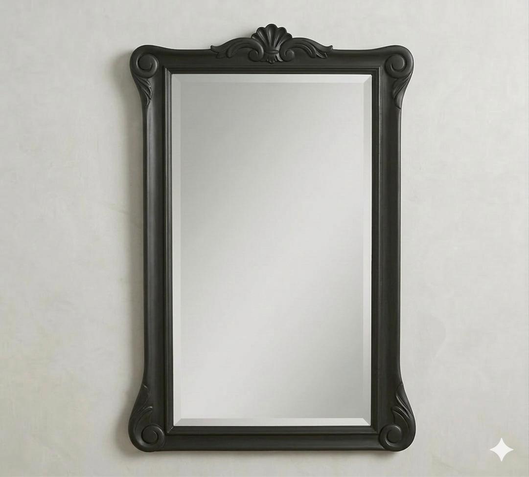 A vertical wall mirror with a bold black-carved frame, featuring the signature Menara scrollwork at the crown and base for a dramatic focal point.
