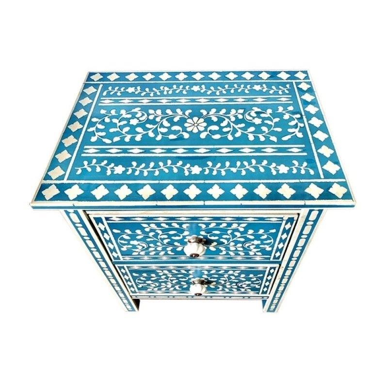 Isolated top surface of a teal blue bone inlay nightstand featuring hand-laid white floral wreath center, leafy vine border rows, and diamond tile border on all four edges.