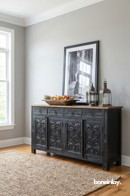 Bold black carved sideboard highlighted by ornate botanical motifs and a striking distressed finish.