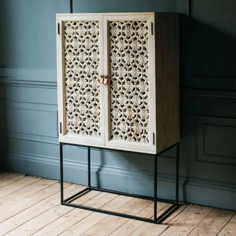 Bohemian lattice liquor cabinet in light sand-washed finish with carved doors, shown in a front view.