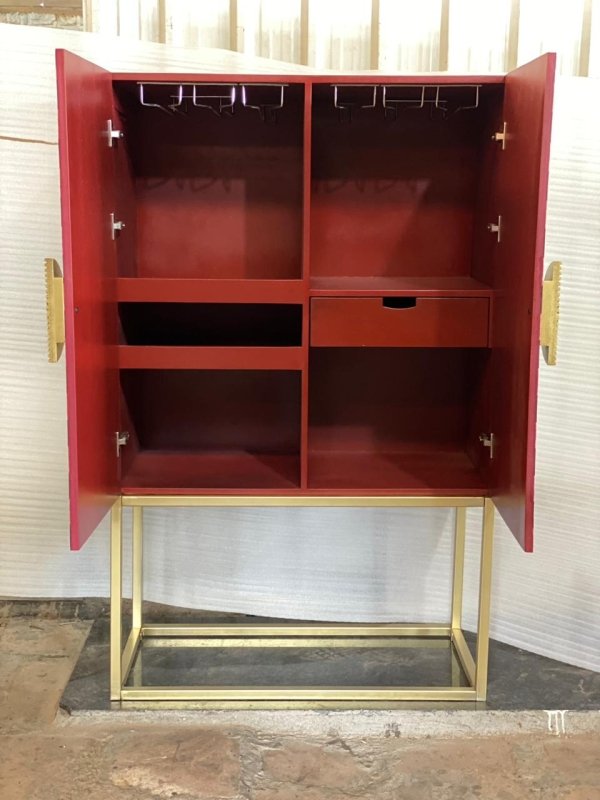 Open interior of bone inlay bar cabinet showing multiple storage shelves, hanging wine glass rack at top, built-in drawer and gold brass hinges with gold metal base
