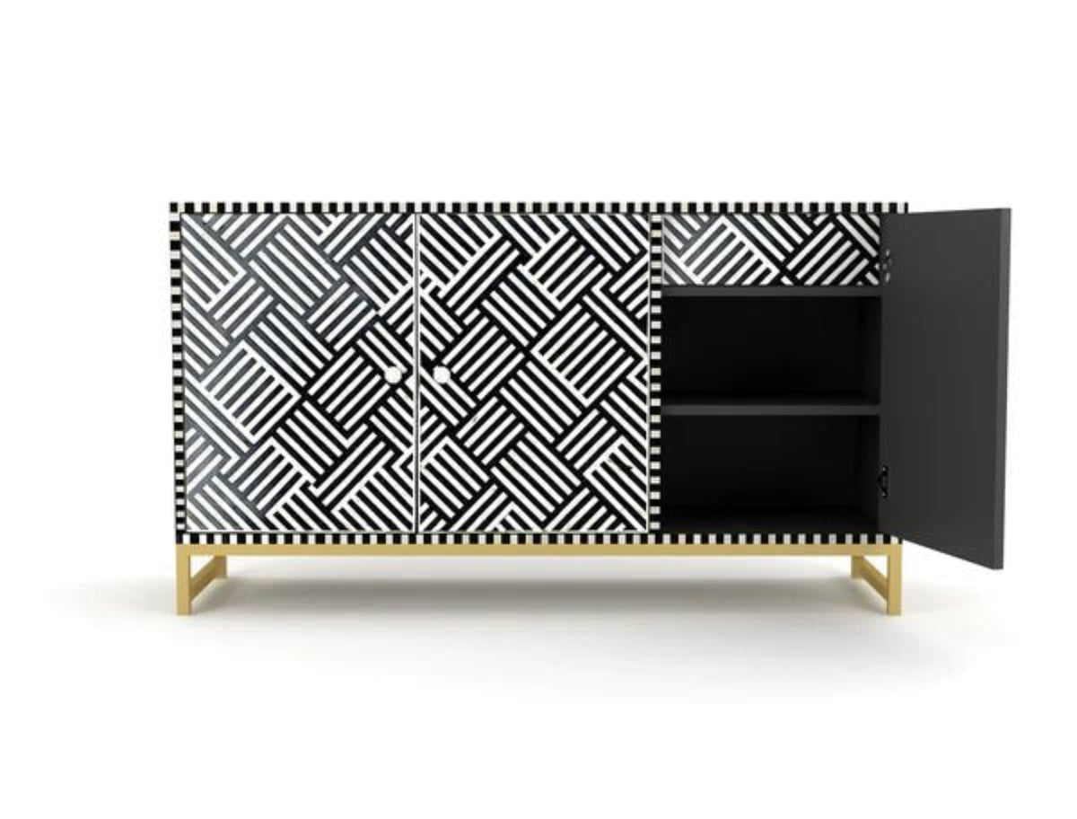 Bone inlay black and white credenza cabinet with right door open revealing interior shelf, geometric pattern doors and brass base on white background