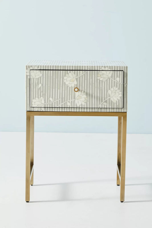Grey and white bone inlay one-drawer nightstand with all-over vertical stripe and scattered floral pattern on body and top, small brass ring knob, and slim gold metal stand.