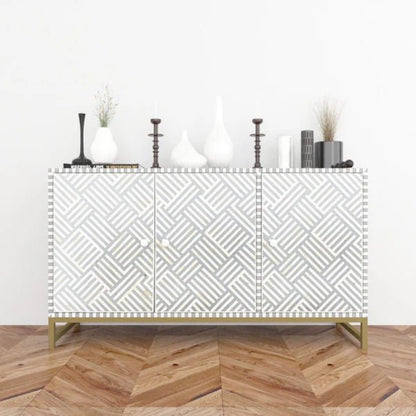 Bone inlay grey and white geometric pattern sideboard cabinet styled with white vases and candlesticks on herringbone wood floor in a bright room
