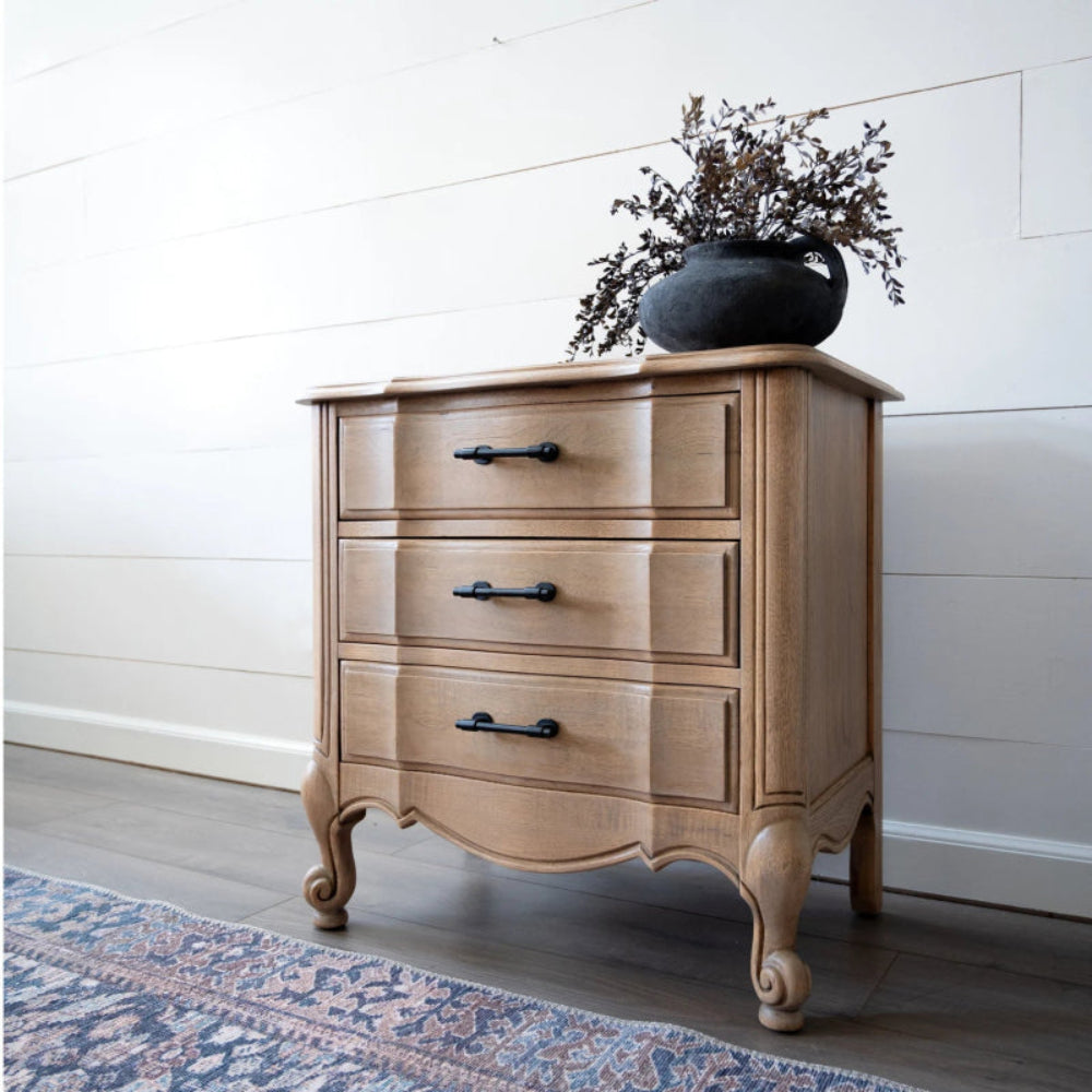 Brass hardware two-drawer chest topped with a potted plant, shown in a top angled view.