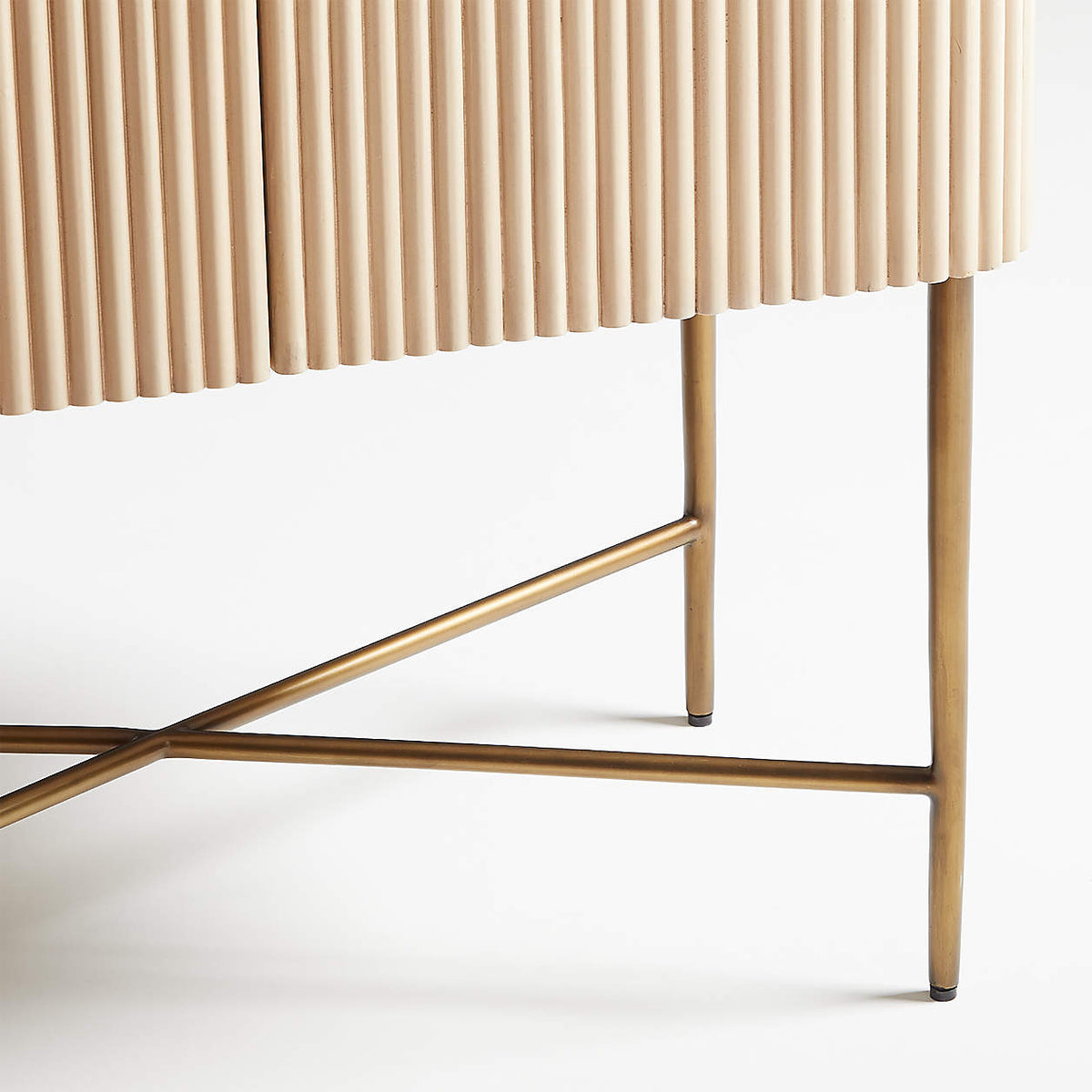 Brass X-leg bar cabinet, close-up of the crossed brass legs supporting the fluted wood cabinet base.