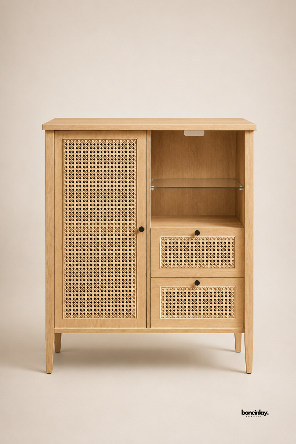 Artisan-crafted light oak cabinet featuring woven rattan cane door and drawer fronts, black knob hardware, and an open display niche with a glass shelf. Set on a neutral studio background, this multi-functional storage unit provides clean Scandinavian lines, breathable natural textures, and ample organization for living spaces.