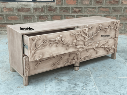 Carved Bird Lowboy in pale natural wood, open drawer view showing a pulled-out upper drawer and patterned front.