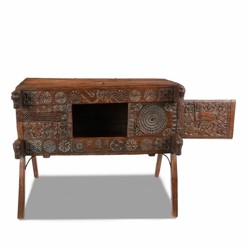 Carved blanket chest in solid wood, front view with the sliding door open to reveal the dark interior.