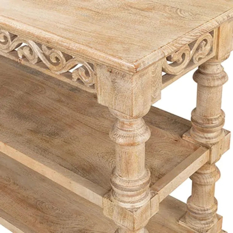Carved corner accent table with scrollwork in a light wood finish, angled close-up of the top corner and turned leg.