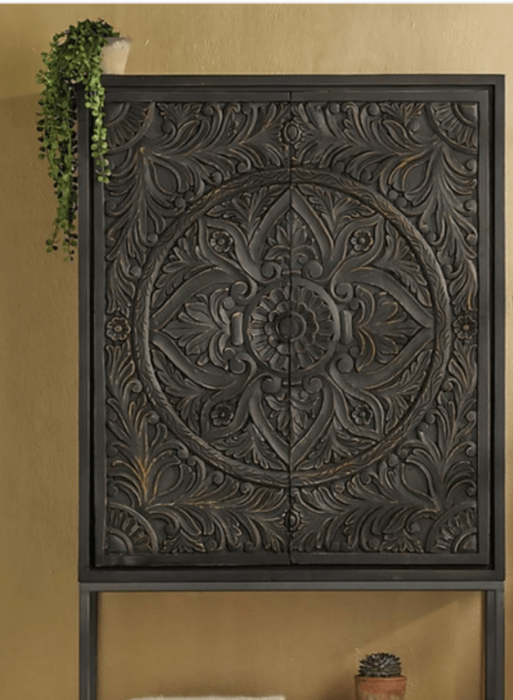 Carved Door Accent Cabinet in dark wood, front view showing the patterned doors above its open lower shelf.