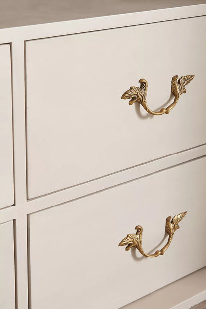 Carved Drawer Chifforobe in a light wood finish, close-up of a drawer front with its decorative brass pull.