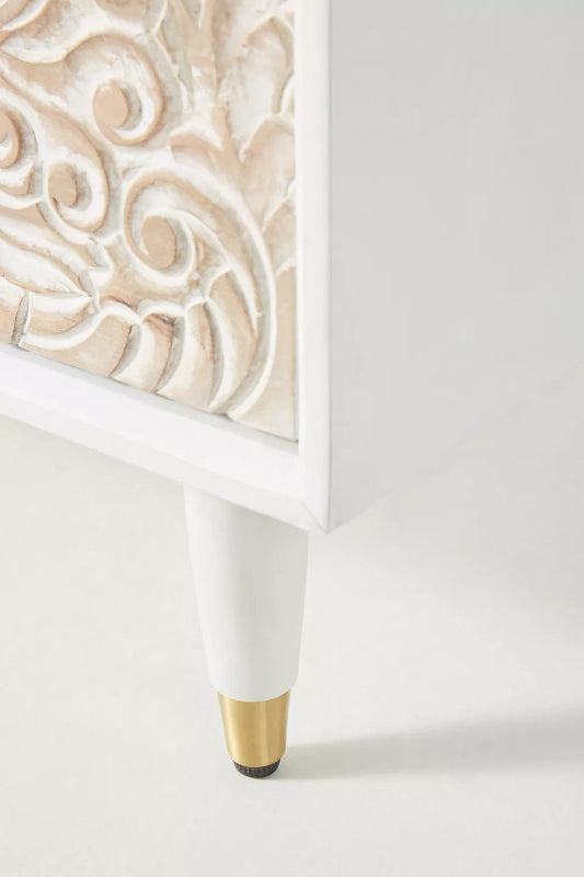 Close-up of a leg on the Gulliver wood dresser, showing the support beneath the hand-carved six-drawer cabinet.