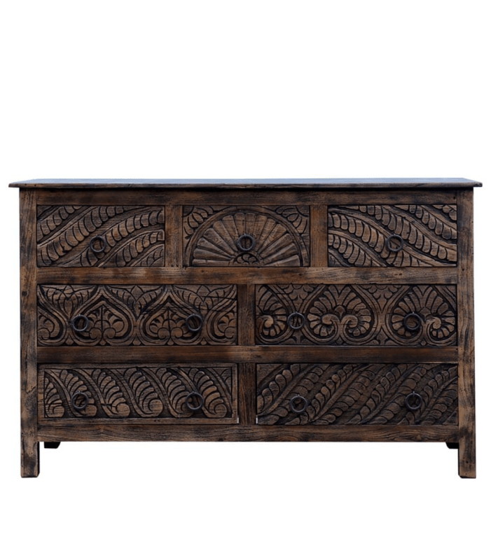 Seven-drawer chest of drawers in dark wood, with carved drawer fronts and metal ring pulls on display.