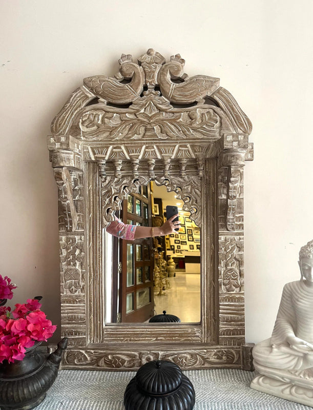 Carved Wood Looking Glass with a rustic finish, front view showing floral pillars and paired peacocks above the glass.