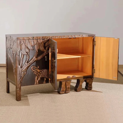 This wooden buffet features an elephant design carved into its doors, framed by decorative jungle foliage.