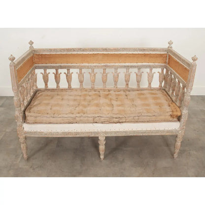 Classic slatted settee in pale wood with an upholstered seat, front view highlighting its tall back and turned legs.