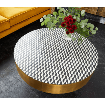 Top view of a round bone inlay coffee table with a black and white checkerboard diamond mosaic pattern, framed by a wide gold metal rim and centered over a black pedestal base, emphasizing the geometric tabletop design.