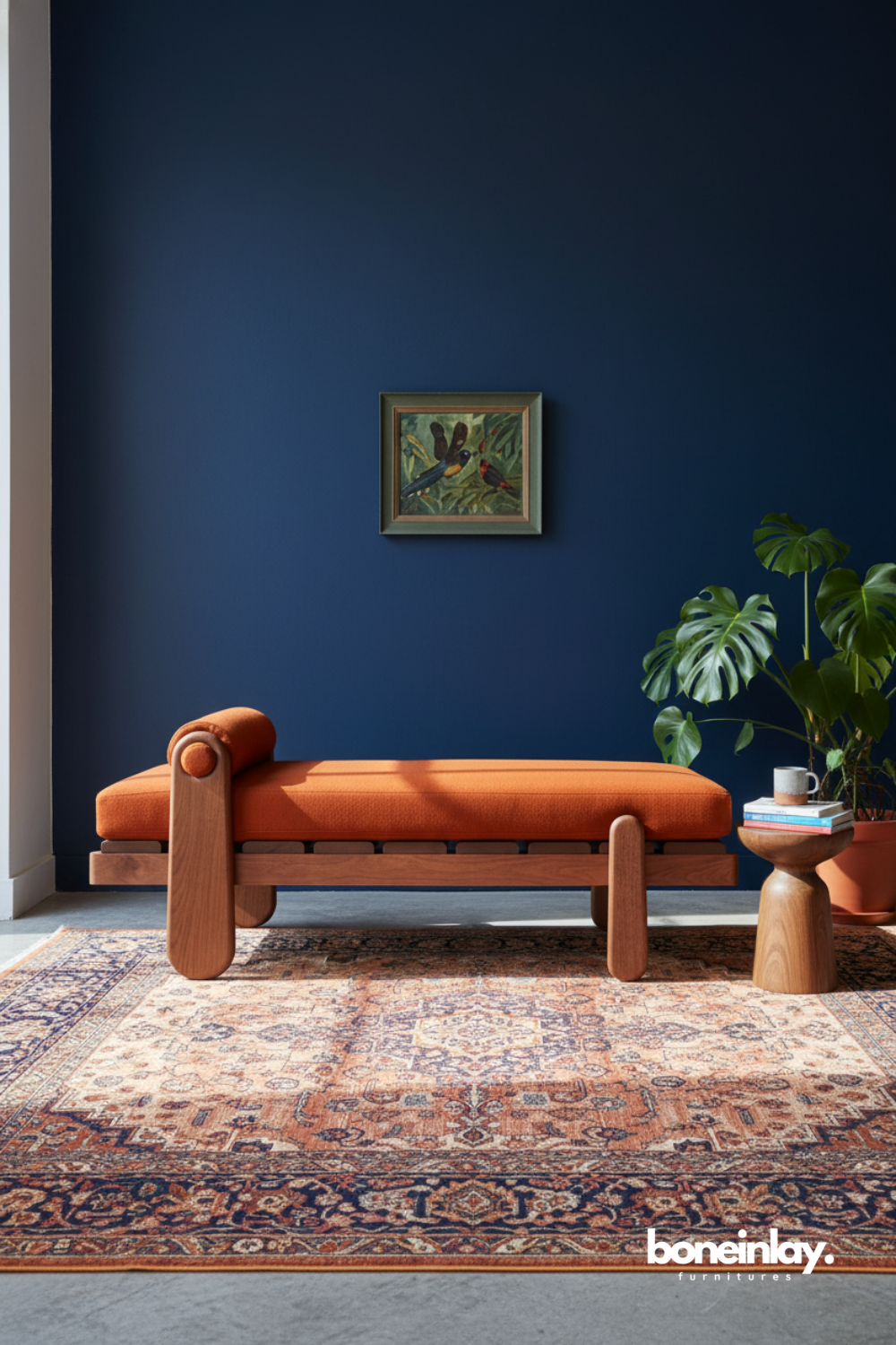 Contemporary wooden chaise lounge with burnt orange upholstery styled against a deep navy accent wall.