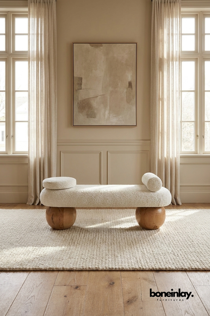 Modern boucle upholstered bench with sculptural wooden sphere legs, contemporary accent seating in soft ivory textured fabric.