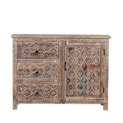 Distressed carved cabinet in a front view, showing three stacked drawers beside a cabinet door with floral panels.