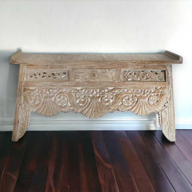 Distressed wood sofa table with carved apron, side profile view on wood flooring.
