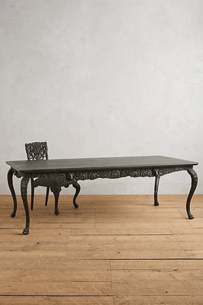 Ebony dining room table in solid wood, front view showing a dark rectangular tabletop above curved legs.