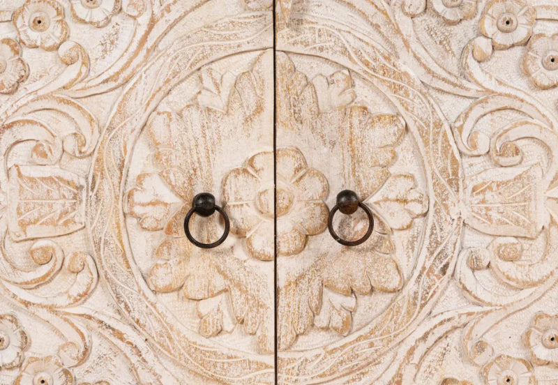 Elephant Carved Media Cabinet in a front view of two pale wood doors, with dark round knobs and carved floral details.
