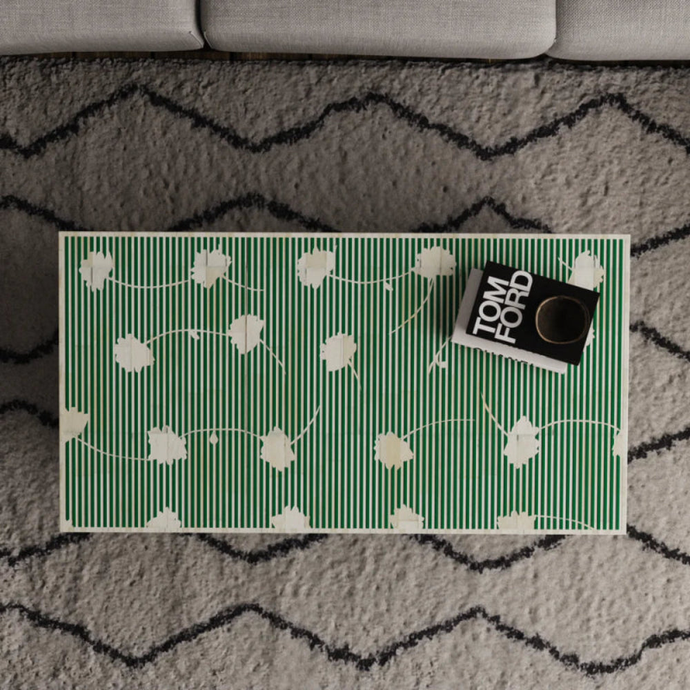 Overhead view of emerald green bone inlay coffee table surface featuring intricate white floral and stripe pattern — handmade artisan centerpiece.