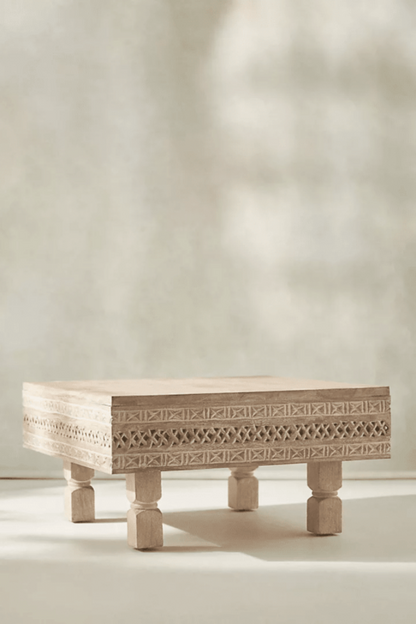 Ezana sand-finish wood coffee table with a square carved frame and geometric lattice band, shown in a front view.