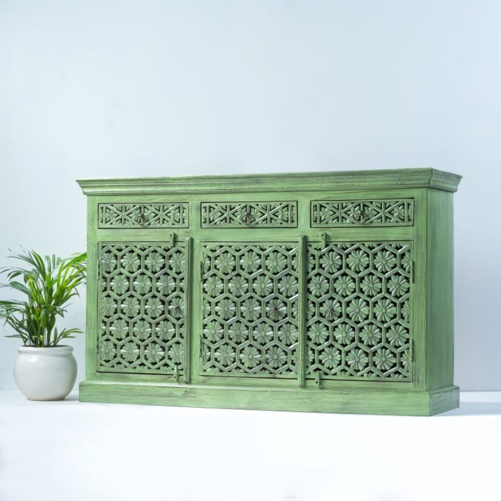 Floral carved server in sage-green wood, angled front view showing its plain right side and broad plinth base.