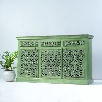 Floral carved server in sage-green wood, angled front view showing its plain right side and broad plinth base.