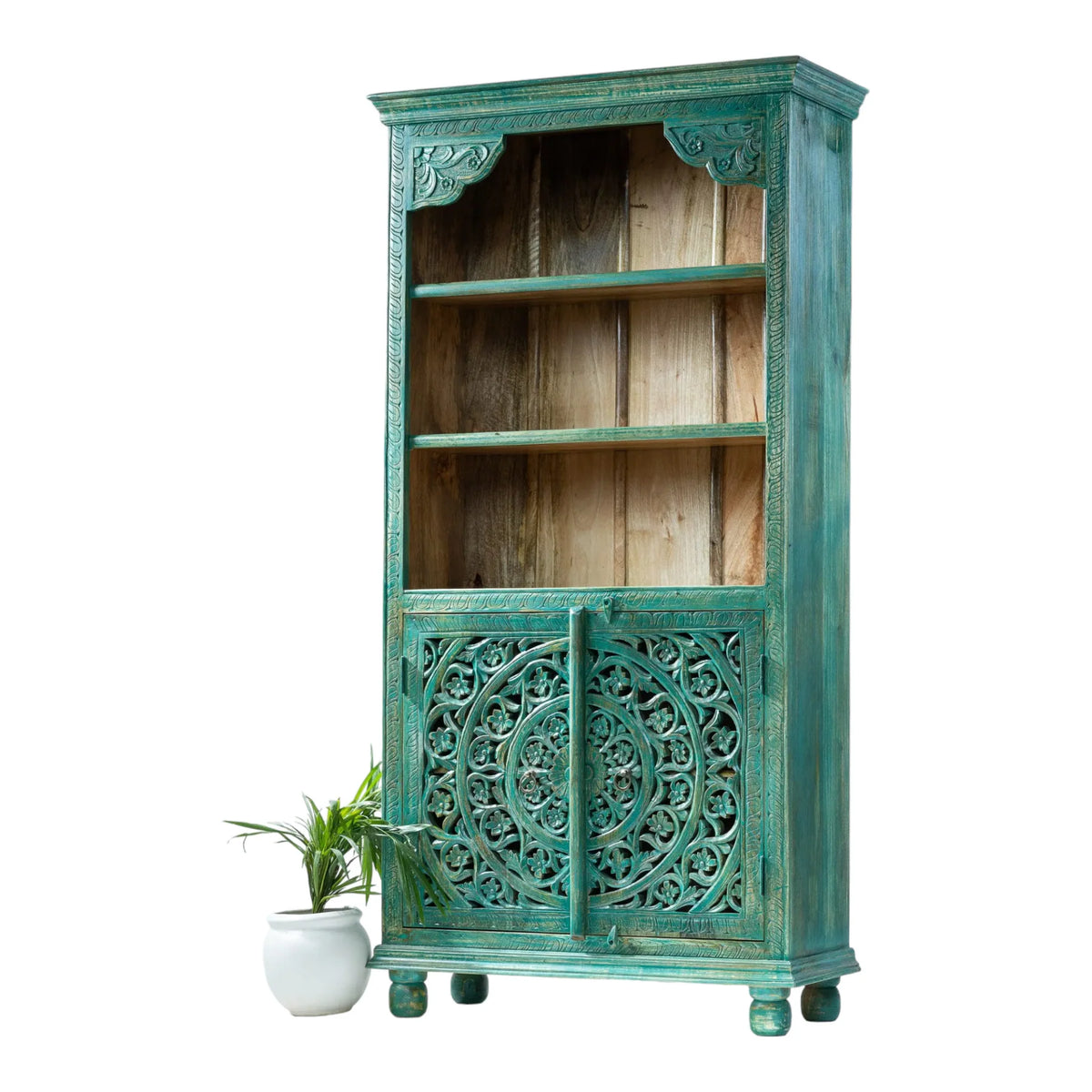 Floral carved shelving unit in teal wood, front view angled from the right showing closed doors and the side panel.