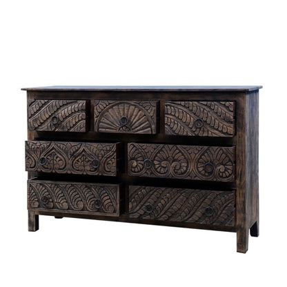 A wood bureau with seven drawers, its dark finish framing floral carving across the drawer faces.