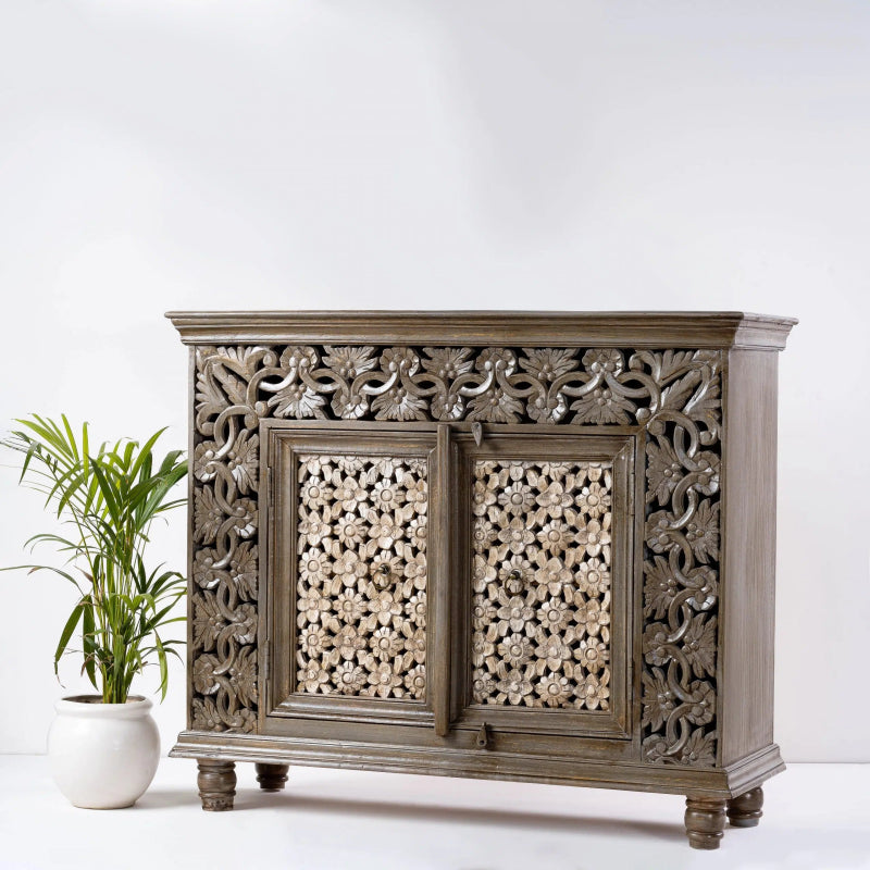 Floral carved wood server in a natural finish, angled front view showing its plain right side and pierced flower doors.