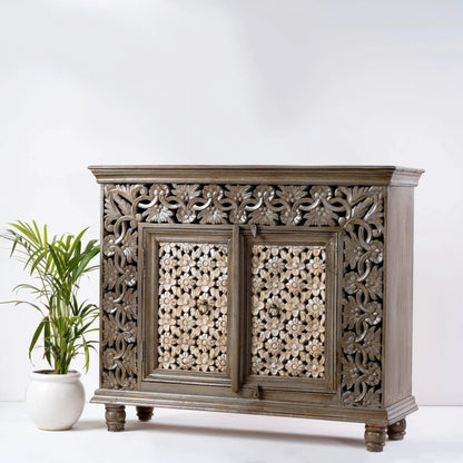 Floral carved wood server in a natural finish, angled front view showing its plain right side and pierced flower doors.