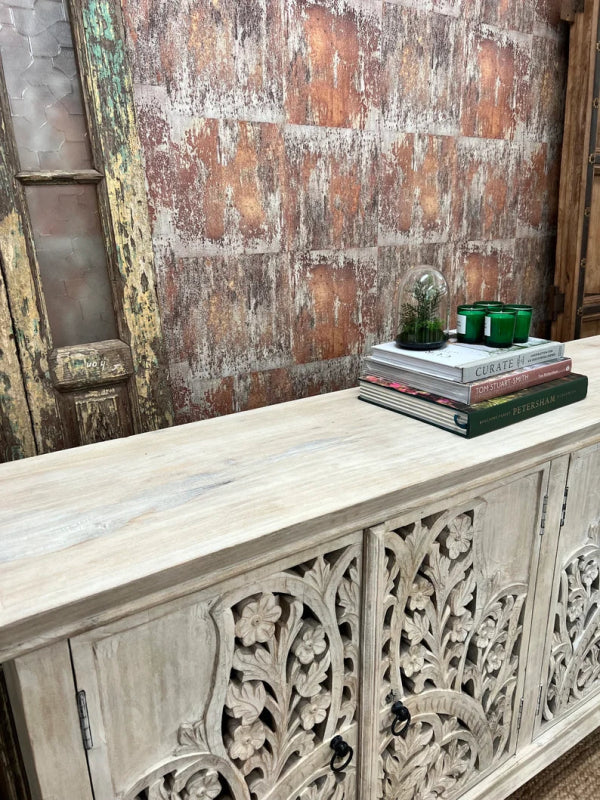 Floral fretwork wood server in a rustic finish, top view at an angle showing the long surface, books and carved doors.