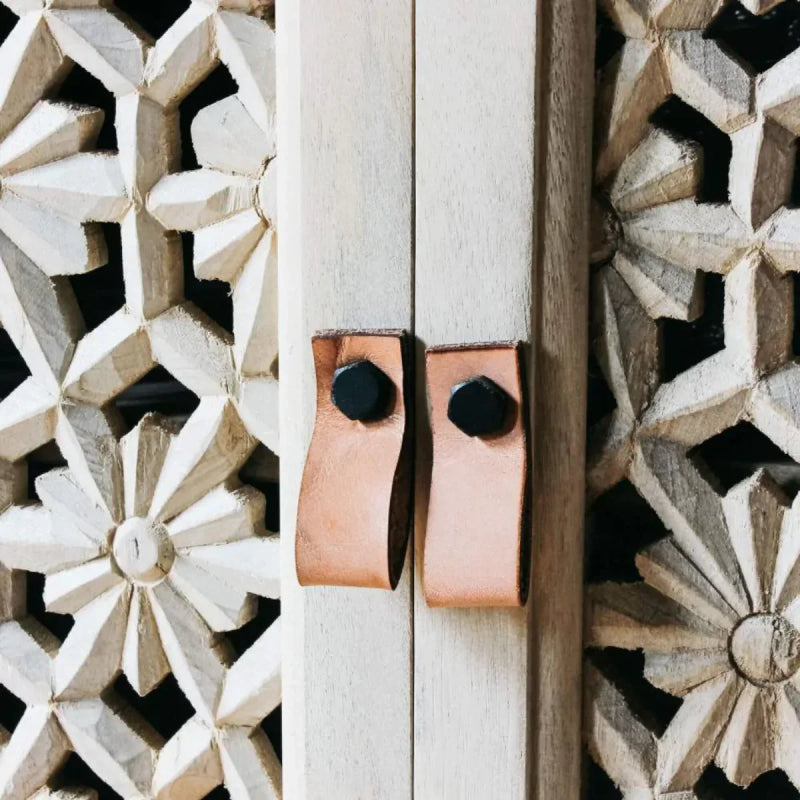 Floral lattice accent cabinet in sand-washed wood, a close-up of the carved lattice door and handles.