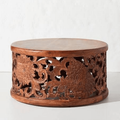 Floral wood accent table in a deep natural finish, front view revealing carved blooms and an open drum base.