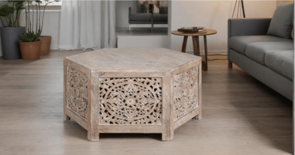 Floral Wood Cocktail Table in a pale natural finish, front view showing the hexagonal top and carved openwork sides.