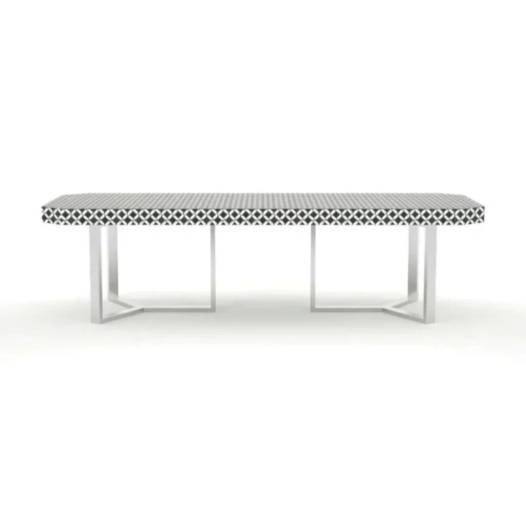 Geometric bone inlay dining table with intricate black and white pattern and stainless steel cross-frame base on white background