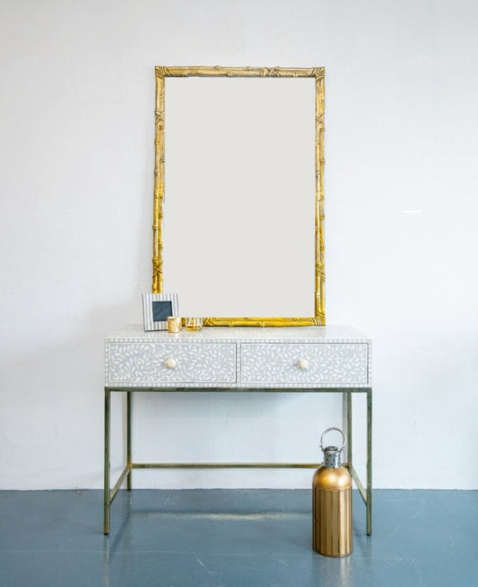 Geometric white bone inlay 2-drawer console desk with gold metal frame, styled with mirror and decorative accents in a minimal room setting