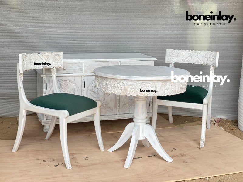 Hand-carved Menagerie dinette set in rustic wood, front view with green upholstered chairs and a matching buffet behind.