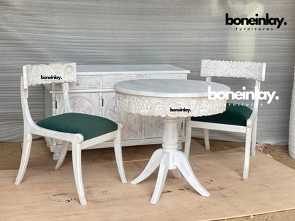 Hand-carved Menagerie dinette set in rustic wood, front view with green upholstered chairs and a matching buffet behind.