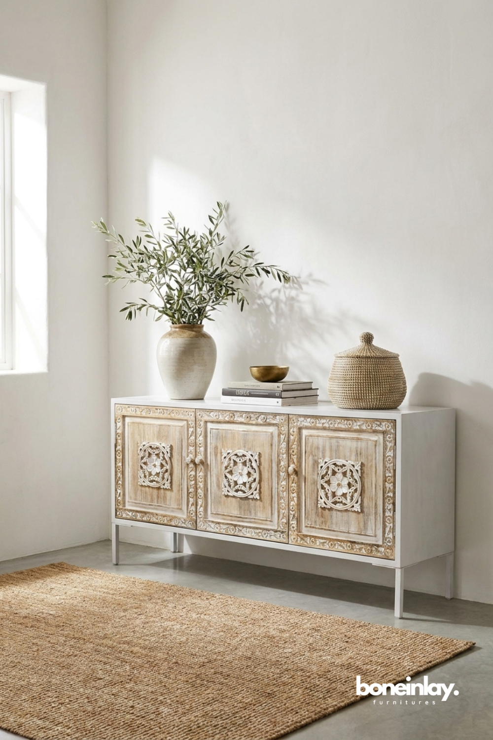 Whitewashed carved storage cabinet adorned with delicate floral medallions, subtle distressed detailing, and elegant transitional style.